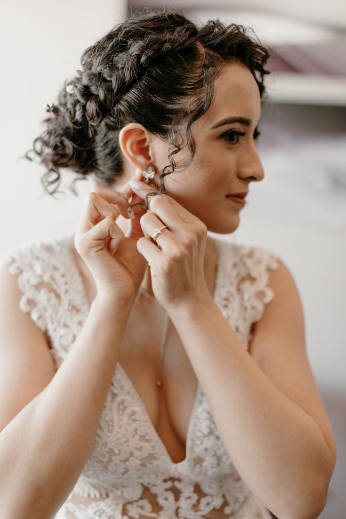 bride putting on earrings