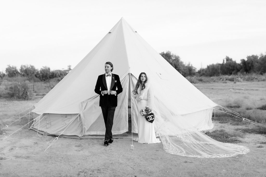 bride and groom standing in front of boujee tent pop up 