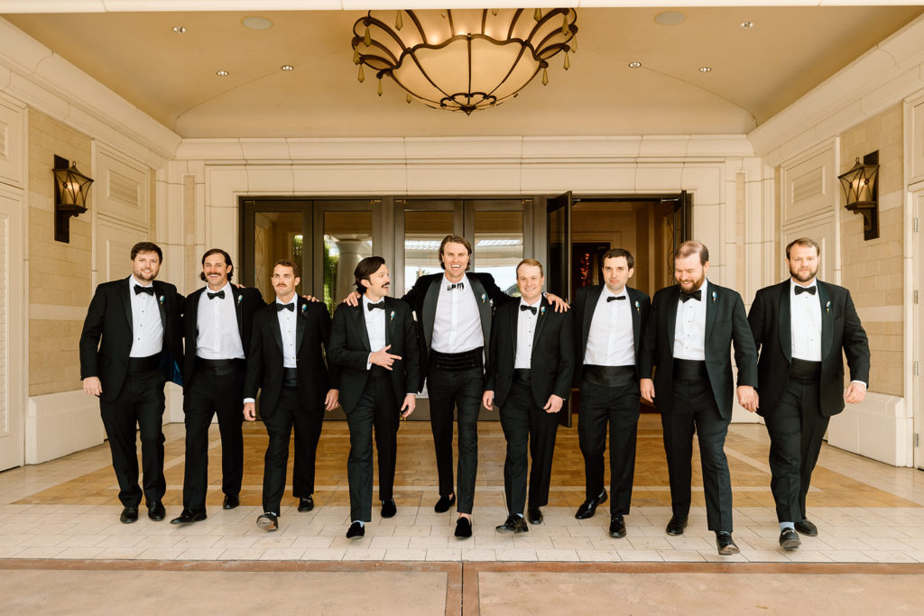 groomsmen walking through hotel, black tie styled boujee