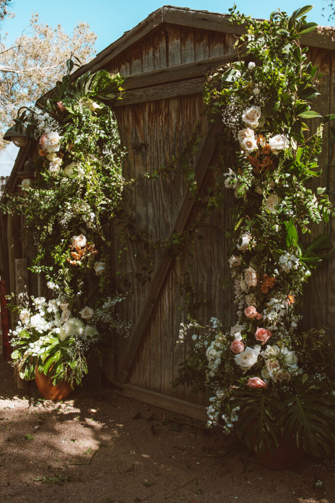garden chic floral arrangement by Bloomingbelle's on wall of barn doors