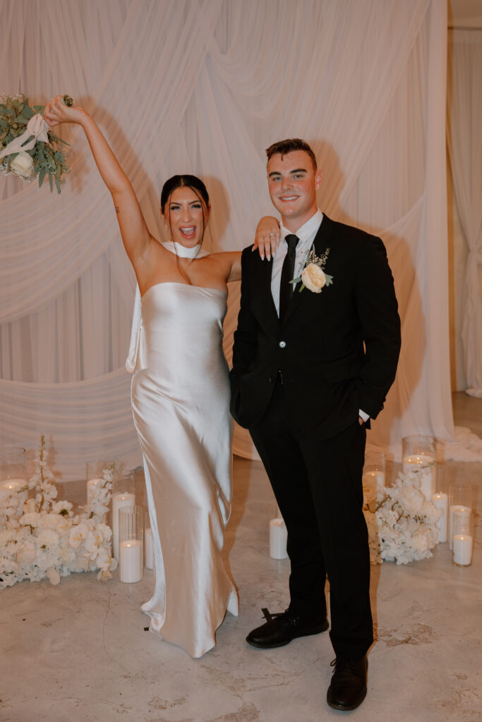 Haley and Nathan holding a bouquet beneath white drapery at That Chapel Downtown in Las Vegas